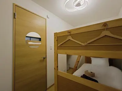 a bedroom with a wooden bunk bed and a mirror at \u51dc\u68ee Rinmori - \u6700\u59277\u540d\u5bbf\u6cca\u53ef - \u6771\u4eac\u30b9\u30ab\u30a4\u30c4\u30ea\u30fc\u307e\u3067\u5f92\u6b69\u570f\u5185 in Tokyo