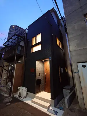 a black house with a wooden door and a stairway at \u51dc\u68ee Rinmori - \u6700\u59277\u540d\u5bbf\u6cca\u53ef - \u6771\u4eac\u30b9\u30ab\u30a4\u30c4\u30ea\u30fc\u307e\u3067\u5f92\u6b69\u570f\u5185 in Tokyo