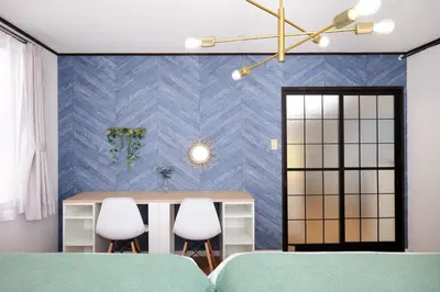 a room with a table and two white chairs at Hatagaya Hotel in Tokyo