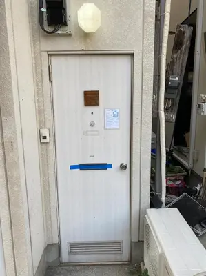 a white door on the side of a building at Hatagaya Hotel in Tokyo