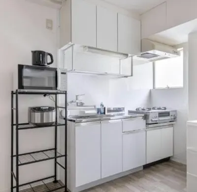 a white kitchen with a stove and a microwave at -Katsura 207- 4 mins to Okubo Station in Tokyo