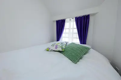 a white bed with a pillow and a window at monthly Oakville \u6839\u6d25 in Tokyo