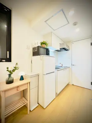 a kitchen with a white refrigerator and a table at Skytree Garden Hotel in Tokyo