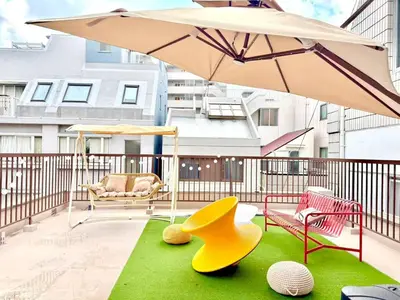 a patio with an umbrella and chairs and a yellow shoe at Yt \u30af\u30ea\u30b9\u30bf\u30eb\u4e09\u7b4b in Tokyo