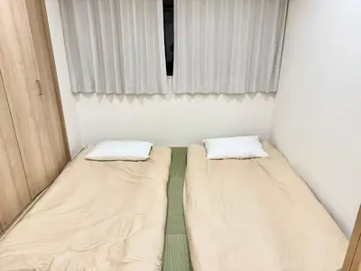 two beds in a small room with a window at Yt \u30af\u30ea\u30b9\u30bf\u30eb\u4e09\u7b4b in Tokyo