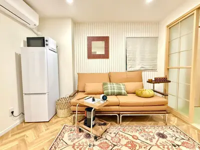 a living room with a couch and a refrigerator at Yt \u30af\u30ea\u30b9\u30bf\u30eb\u4e09\u7b4b in Tokyo