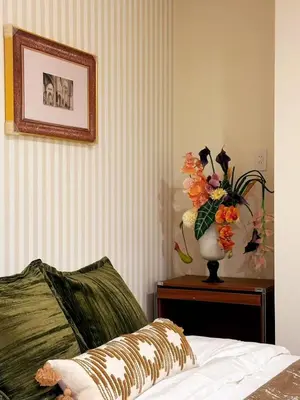 a vase of flowers on a table next to a bed at Yt \u30af\u30ea\u30b9\u30bf\u30eb\u4e09\u7b4b in Tokyo