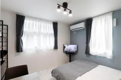 a bedroom with a bed and a flat screen tv at Excellent Arbre in Tokyo
