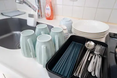 a kitchen counter with plates and utensils and a sink at 504Room Kinshicho Station 5 min walk near Asakusa and Skytree 5th floor with balcony and good soundproofing in Tokyo