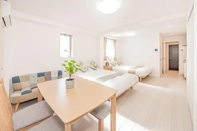 a room with two beds and a table and a couch at JR\u5c71\u624b\u7dda\u5f92\u6b69\u4e94\u5206 ZAITO TOKYO NEST Hotel in Tokyo