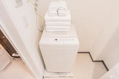a white washer and dryer in a room at JR\u5c71\u624b\u7dda\u5f92\u6b69\u4e94\u5206 ZAITO TOKYO NEST Hotel in Tokyo