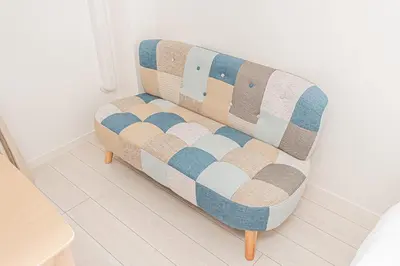 a couch sitting in a room with a wall at JR\u5c71\u624b\u7dda\u5f92\u6b69\u4e94\u5206 ZAITO TOKYO NEST Hotel in Tokyo