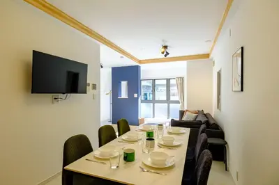 a dining room with a table and chairs and a tv at Stellar inn - \u65e9\u7a32\u7530\u99c5\u304b\u3089\u5f92\u6b693\u5206- \u6700\u59277\u540d\u5bbf\u6cca\u53ef in Tokyo
