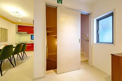 a sliding door leading into a kitchen with green chairs at Stellar inn - \u65e9\u7a32\u7530\u99c5\u304b\u3089\u5f92\u6b693\u5206- \u6700\u59277\u540d\u5bbf\u6cca\u53ef in Tokyo