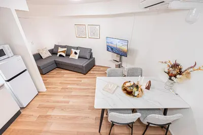 a living room with a table and chairs and a couch at \u897f\u6b66\u65b0\u5bbf\u7dda\u5f92\u6b69\u4e09\u5206 ZAITO Shimoochiai Stay in Tokyo