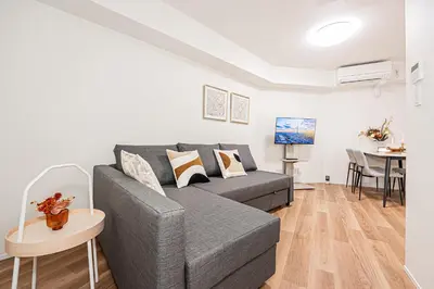 a living room with a gray couch and a table at \u897f\u6b66\u65b0\u5bbf\u7dda\u5f92\u6b69\u4e09\u5206 ZAITO Shimoochiai Stay in Tokyo
