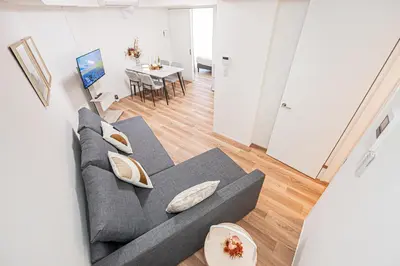 a living room with a gray couch and a table at \u897f\u6b66\u65b0\u5bbf\u7dda\u5f92\u6b69\u4e09\u5206 ZAITO Shimoochiai Stay in Tokyo