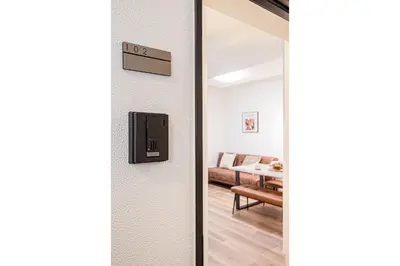 a door leading into a living room with a couch at \u897f\u6b66\u65b0\u5bbf\u7dda\u5f92\u6b69\u4e09\u5206 ZAITO Shimoochiai Stay in Tokyo