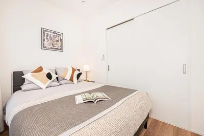 a bedroom with a bed with a book on it at \u897f\u6b66\u65b0\u5bbf\u7dda\u5f92\u6b69\u4e09\u5206 ZAITO Shimoochiai Stay in Tokyo