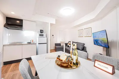 a kitchen and living room with a white table and chairs at \u897f\u6b66\u65b0\u5bbf\u7dda\u5f92\u6b69\u4e09\u5206 ZAITO Shimoochiai Stay in Tokyo
