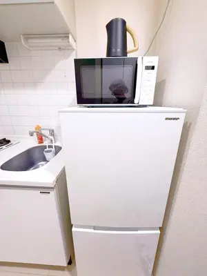 a microwave sitting on top of a white refrigerator at Cute Anime-Style Room Near Kinshicho Station in Tokyo