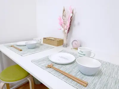 a white table with bowls and chopsticks on it at Cute Anime-Style Room Near Kinshicho Station in Tokyo