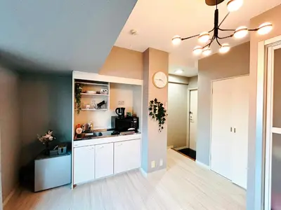 a kitchen with white cabinets and a clock on the wall at \u30e9\u30a4\u30aa\u30f3\u30ba\u30d7\u30e9\u30b6\u65b0\u5bbf901 in Tokyo