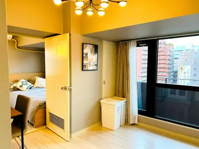 a bedroom with a bed and a large window at \u30e9\u30a4\u30aa\u30f3\u30ba\u30d7\u30e9\u30b6\u65b0\u5bbf901 in Tokyo