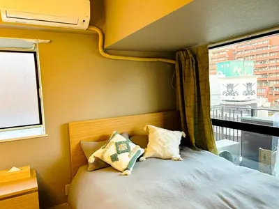 a bed with two pillows sitting next to a window at \u30e9\u30a4\u30aa\u30f3\u30ba\u30d7\u30e9\u30b6\u65b0\u5bbf901 in Tokyo