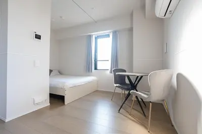 a room with a table and two chairs and a bed at \u6d45\u8349\u99c5\u5f92\u6b69\u570f \u4ea4\u901a\u81f3\u4fbf \u6d45\u8349\u5bfa\u96f7\u9580\u8fd1\u304f \u89b3\u5149 \u30b7\u30e7\u30c3\u30d4\u30f3\u30b0 \u30b0\u30eb\u30e1\u62e0\u70b9 Qs in Tokyo