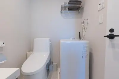 a white bathroom with a toilet and a refrigerator at \u6d45\u8349\u99c5\u5f92\u6b69\u570f \u4ea4\u901a\u81f3\u4fbf \u6d45\u8349\u5bfa\u96f7\u9580\u8fd1\u304f \u89b3\u5149 \u30b7\u30e7\u30c3\u30d4\u30f3\u30b0 \u30b0\u30eb\u30e1\u62e0\u70b9 Qs in Tokyo