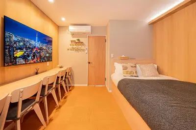a hotel room with a bed and a row of chairs at Komorebi Asakusa Cozy 6P Stay The 77 House Tokyo in Tokyo