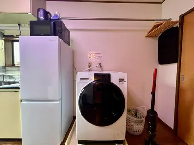 a toilet in a kitchen next to a refrigerator at Credo House Shin-Okubo in Tokyo