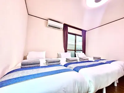 a row of beds in a room with a window at Credo House Shin-Okubo in Tokyo