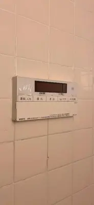 a microwave on a white tiled wall at Aila Room in Tokyo