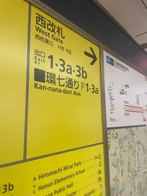 a sign for the west gate of the komachi mineral park at Aila Room in Tokyo