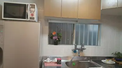 a kitchen with a sink and a microwave at Aila Room in Tokyo