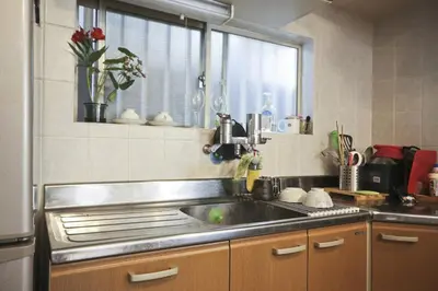 a kitchen with a stainless steel sink and a window at Aila Room in Tokyo
