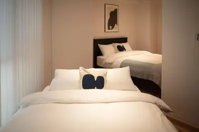 two beds in a hotel room with white sheets at Takinogawa-1ldk\u677f\u6865 KI0429 in Tokyo