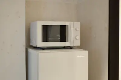 a microwave sitting on top of a refrigerator at Takinogawa-1ldk\u677f\u6865 KI0429 in Tokyo