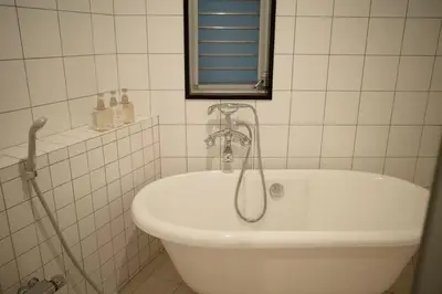 a bathroom with a tub and a sink with a mirror at Takinogawa-1ldk\u677f\u6865 KI0429 in Tokyo