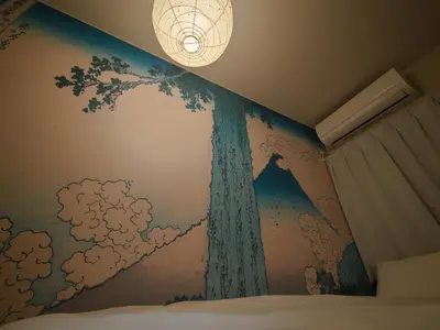 a bedroom with a tree mural on the wall at The Nest Koenji Cozy Stay near Station Easy Access to Shinjuku in Tokyo