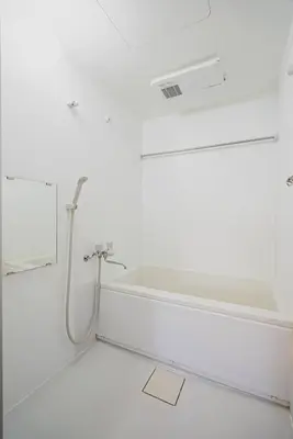 a white bathroom with a sink and a bath tub at En House Asakusa in Tokyo