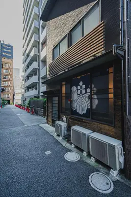 a building with two air conditioners on the side of it at En House Asakusa in Tokyo