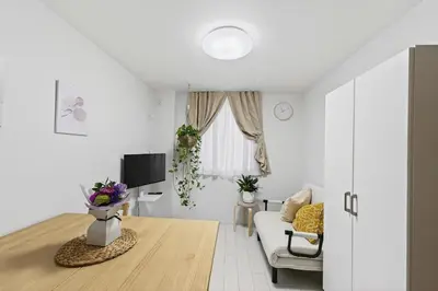a white living room with a couch and a tv at \u30b3\u30d5\u30ec\u9ad8\u7530\u99ac\u5834102 in Tokyo