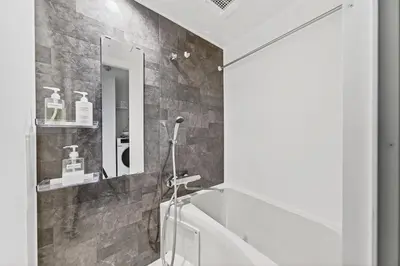 a bathroom with a tub and a mirror at \u30b3\u30d5\u30ec\u9ad8\u7530\u99ac\u5834102 in Tokyo