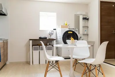 a kitchen with a white table and white chairs at Private Apartment HOTEL Ceres Kamiikebukuro 401 in Tokyo