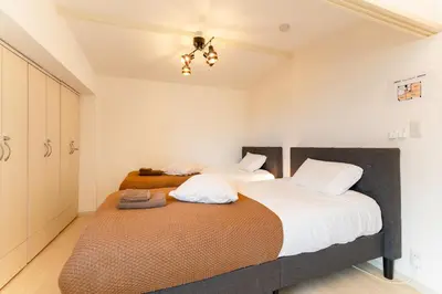 a bedroom with two beds and a ceiling at Private Apartment HOTEL Ceres Kamiikebukuro 401 in Tokyo