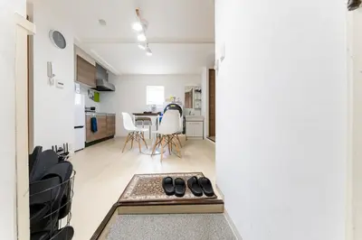 a pair of shoes sitting on a bench in a living room at Private Apartment HOTEL Ceres Kamiikebukuro 401 in Tokyo