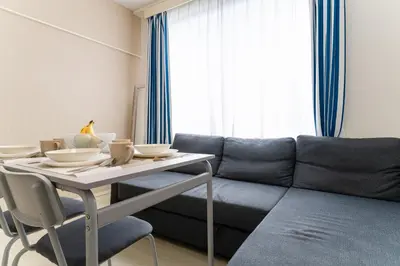 a living room with a table and a couch at Private Apartment HOTEL Ceres Kamiikebukuro 401 in Tokyo